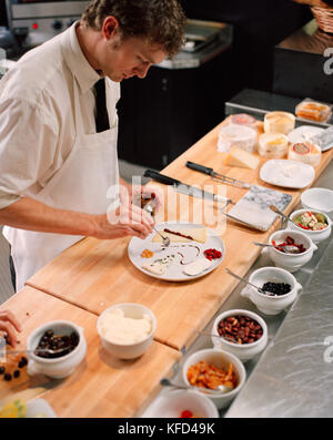 USA, California, Los Angeles, chef decorating a cheese plate at the cheese bar of Comme Ca Restaurant. Stock Photo