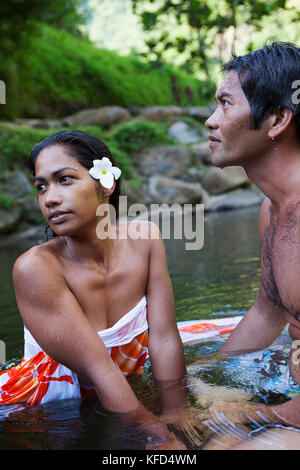 FRENCH POLYNESIA, Tahiti. A local swiming hole close to the town of Papenoo along a dirt road towards the center of the island. A local couple swimmin Stock Photo