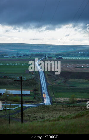 USA, Oregon, Enterprise, a truck drives down a road in the rain at dusk Stock Photo