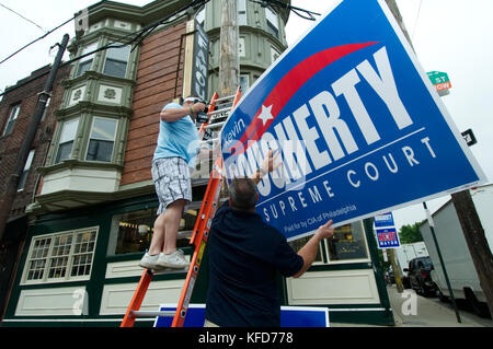 Labor union members mount signs in support of a candidate, outside a popular South Philadelphia, PA diner and meeting spot for local politicians, on E Stock Photo