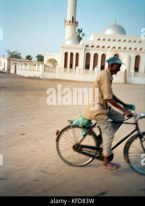ERITREA, Massawa, a man rides his bicycle in front of a mosque in Massawa Stock Photo