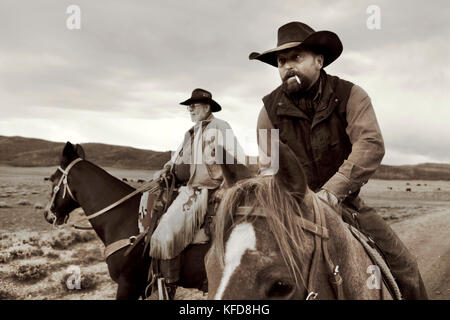 USA, Wyoming, Encampment, cowboys on horseback get ready to round up cattle for a branding, Big Creek Ranch (B&W) Stock Photo