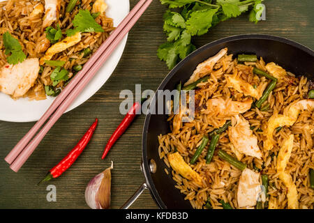 Indonesian Style Nasi Goreng Chicken and Rice Meal On A Green Wooden Background Stock Photo