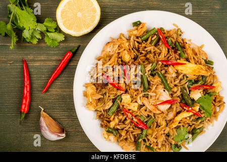 Indonesian Style Nasi Goreng Chicken and Rice Meal On A Green Wooden Background Stock Photo