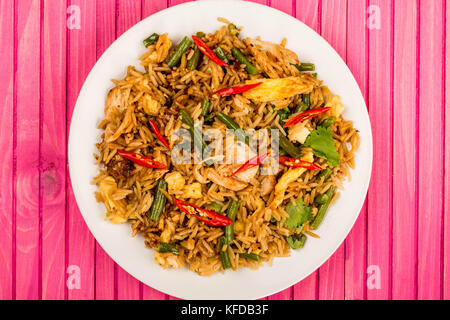 Indonesian Style Nasi Goreng Chicken and Rice Meal On A Pink Wooden Background Stock Photo
