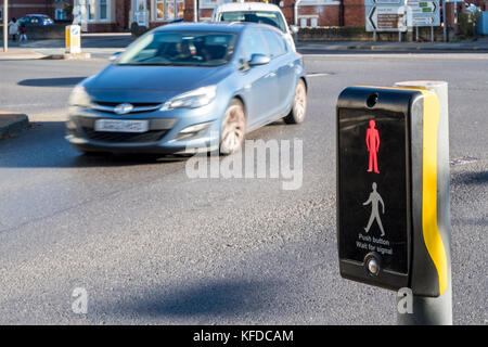 Stop signal at a puffin pedestrian crossing control. Puffin crossing showing red man while traffic passing, Nottinghamshire, England, UK Stock Photo