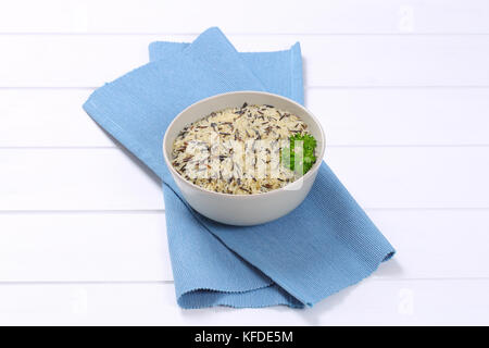 bowl of wild rice on blue place mat Stock Photo