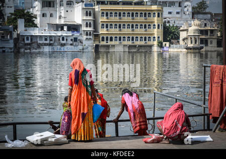 Women in colourful saris standing on the lake shore in Udaipur. Stock Photo