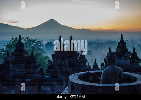 Borobudur, or Barabudur, a 9th century Mahayana Buddhist temple in Magelang. Elevated view of the temple stupas and terraces and Mount Bromo and mount Stock Photo