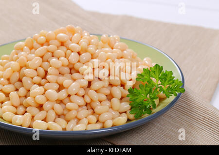 plate of canned white beans on beige place mat - close up Stock Photo