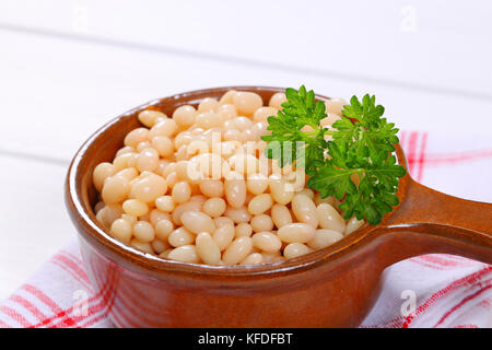 saucepan of canned white beans on checkered dishtowel - close up Stock Photo
