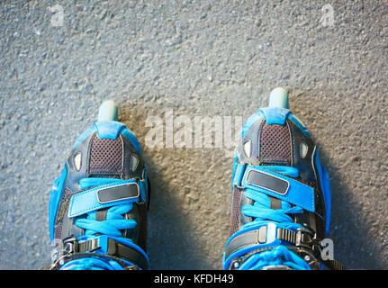 Closeup of blue inline roller skates - first person view. Stock Photo