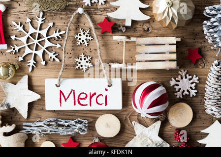Signboard With French Text Merci Means Thank You. Christmas Decoration Like Sled, Ball, Christmas Tree And Snowflake. Brown Rustic Woodn Background. N Stock Photo