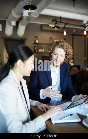Start-up meeting of two young confident employees in cafe Stock Photo