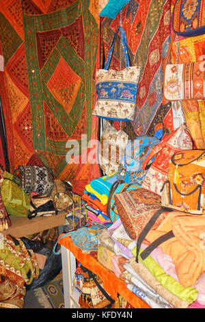 Stacks of colorful handmade pure wool rugs and souvenirs in tourist stall of Old Bazaar of Antalya, Turkey