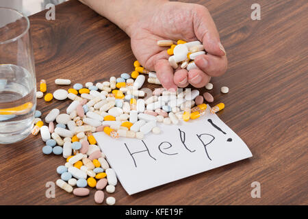 Person Holding Pills In Hand With Help Text On Paper Stock Photo