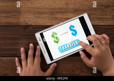 transferring money online - woman transferring money using digital tablet. business concept. Stock Photo