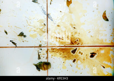 Colorful stains and broken glass on white bathroom tiles. Stock Photo
