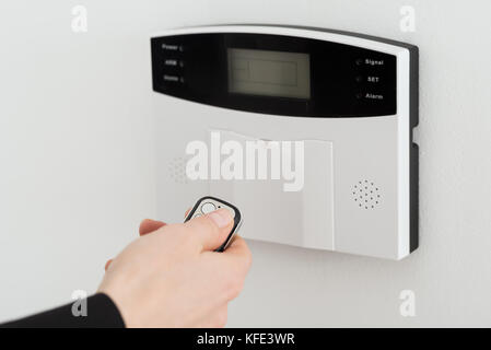Close-up Of Woman Hand Using Remote To Operate Entrance Security System Stock Photo