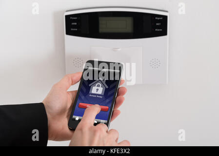 Close-up Of Businesswoman Hand Disarming Security System Of Door Stock Photo