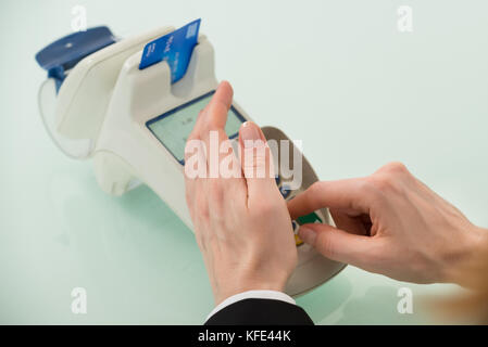 Close-up Of Woman Hand Using Credit Card Machine Stock Photo