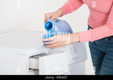 Closeup of liquid gel detergent pouring from the spout of a