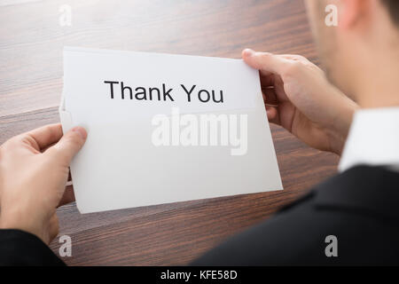 Close-up Of Businessman Holding Thank You Card In Envelope Stock Photo