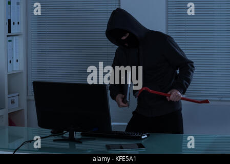 Thief Stealing Laptop From Office At Night Stock Photo