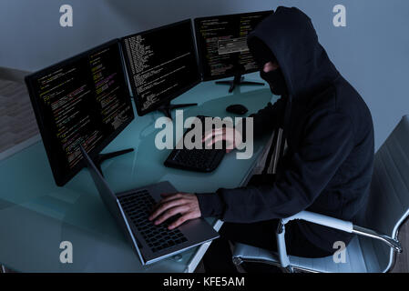 Hacker Stealing Data On Multiple Computers And Laptop Stock Photo
