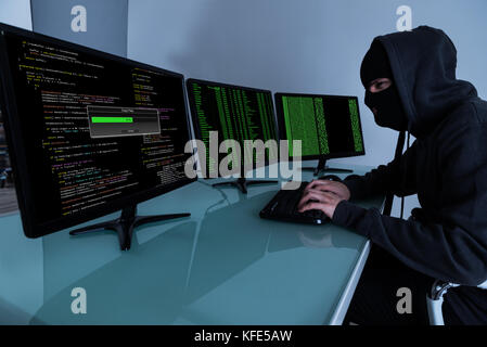 Hacker Stealing Data On Multiple Computers And Laptop Stock Photo