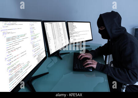 Hacker Stealing Data On Multiple Computers And Laptop Stock Photo