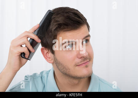 Close-up Of Young Man Combing His Hair With Comb Stock Photo