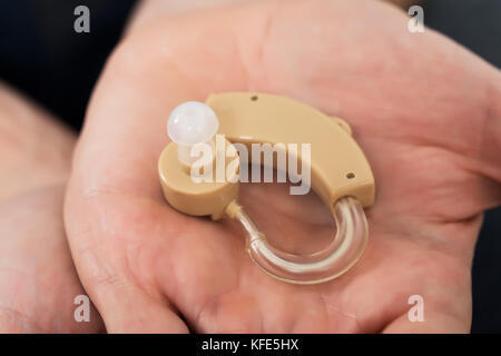 Close-up Of Hearing Aid On Person's Palm Stock Photo