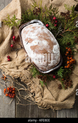 stollen on a wooden table, wrapped in burlap Stock Photo