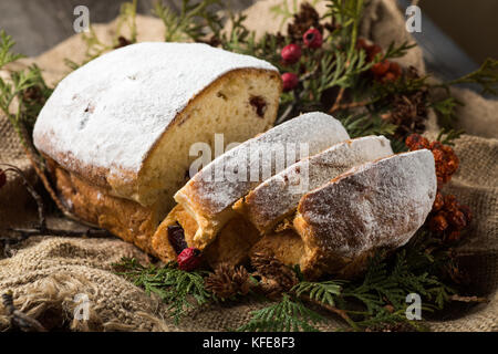 stollen on a wooden table, wrapped in burlap Stock Photo