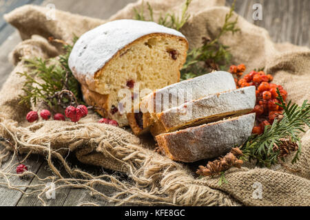 stollen on a wooden table, wrapped in burlap Stock Photo