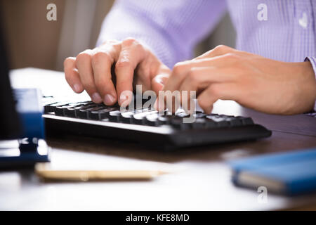Close-up Of A Businessperson's Hand Typing On Computer Keyboard Stock Photo