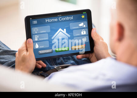 Close-up Of Man Using Home Control System On Digital Tablet Stock Photo