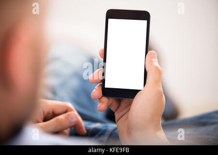 Close-up Of A Man's Hand Holding Cell Phone With White Blank Screen Stock Photo