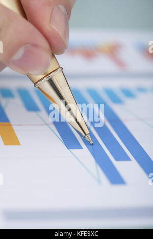 Cropped image of businessman's hand showing diagram on financial report with pen Stock Photo