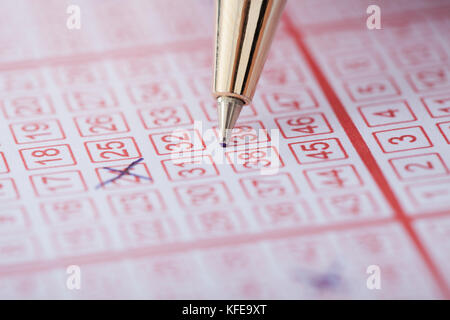 Closeup of pen marking numbers on lottery ticket Stock Photo