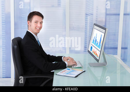 Side view of concentrated businessman working on computer at desk in office Stock Photo