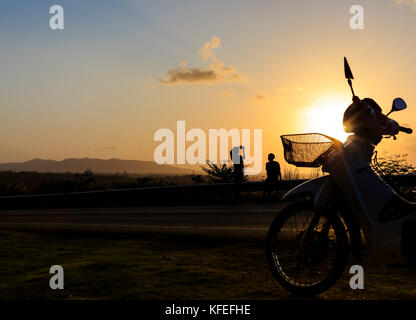 silhouette young photographed and rested on a mountain sunset. Stock Photo