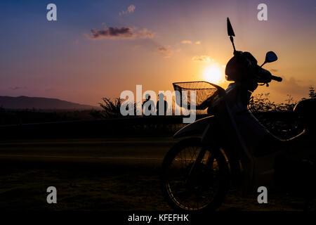 silhouette young photographed and rested on a mountain sunset. Stock Photo