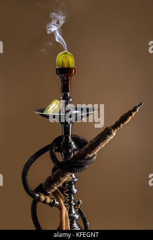 Smoking hookah with fruit head on dark background Stock Photo