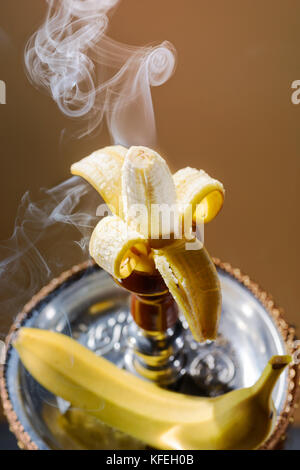 Smoking hookah with fruit head on dark background Stock Photo