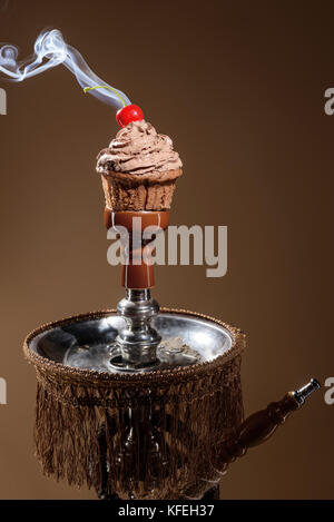 Smoking hookah with fruit head on dark background Stock Photo