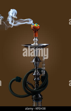 Smoking hookah with fruit head on dark background Stock Photo