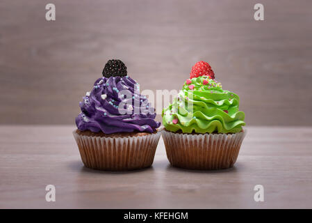 Two Small appetizing muffins with berries on table Stock Photo