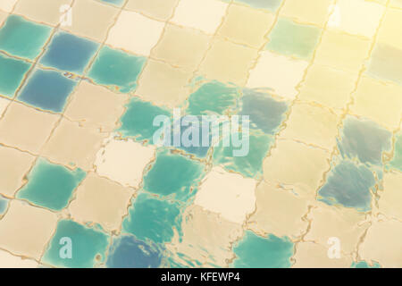 blue ripped water in swimming pool of the hotel. background of water refrection and swimming pool tiles. vintage photo and film style. Stock Photo
